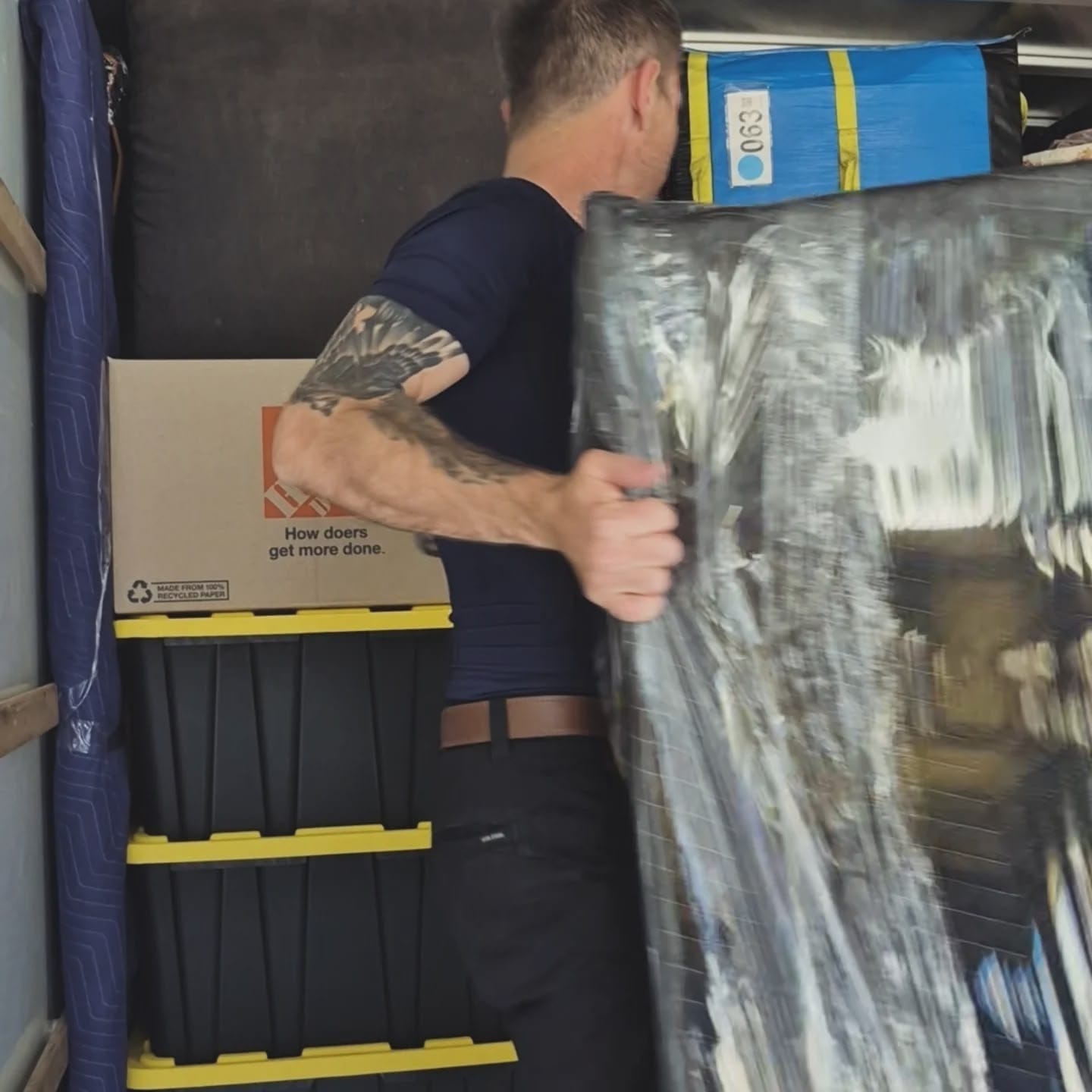 Mighty Movers team member carefully handling wrapped furniture in San Diego